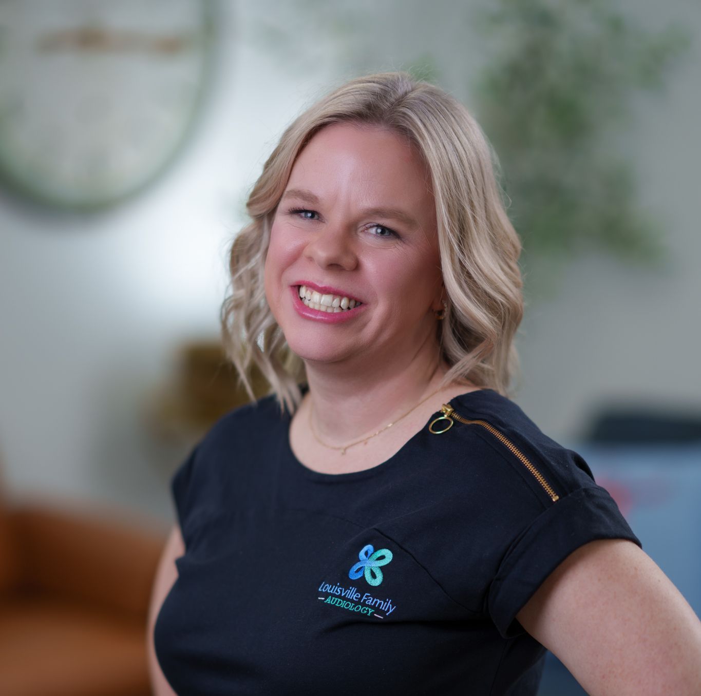 A woman wearing a black shirt with a butterfly embroidered on it
