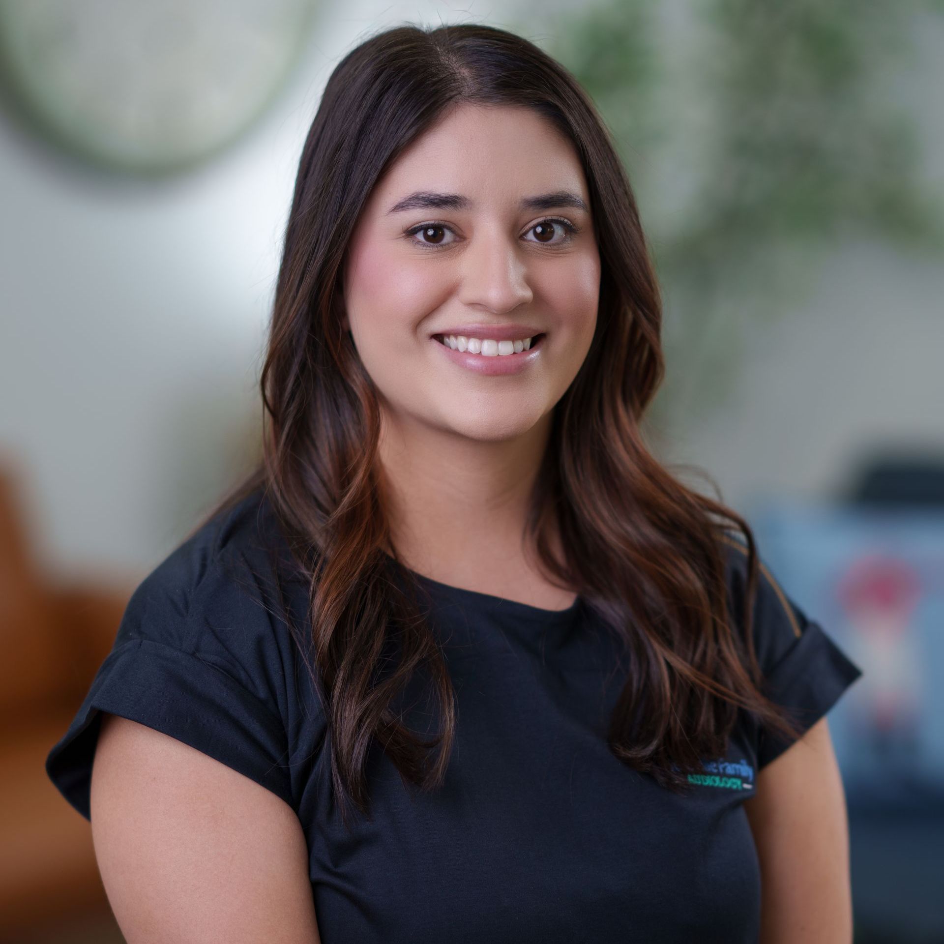 A woman in a black shirt is smiling for the camera.