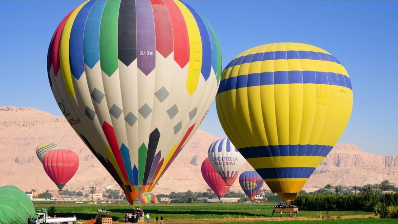 Multiple hot air balloons flying over Luxor
