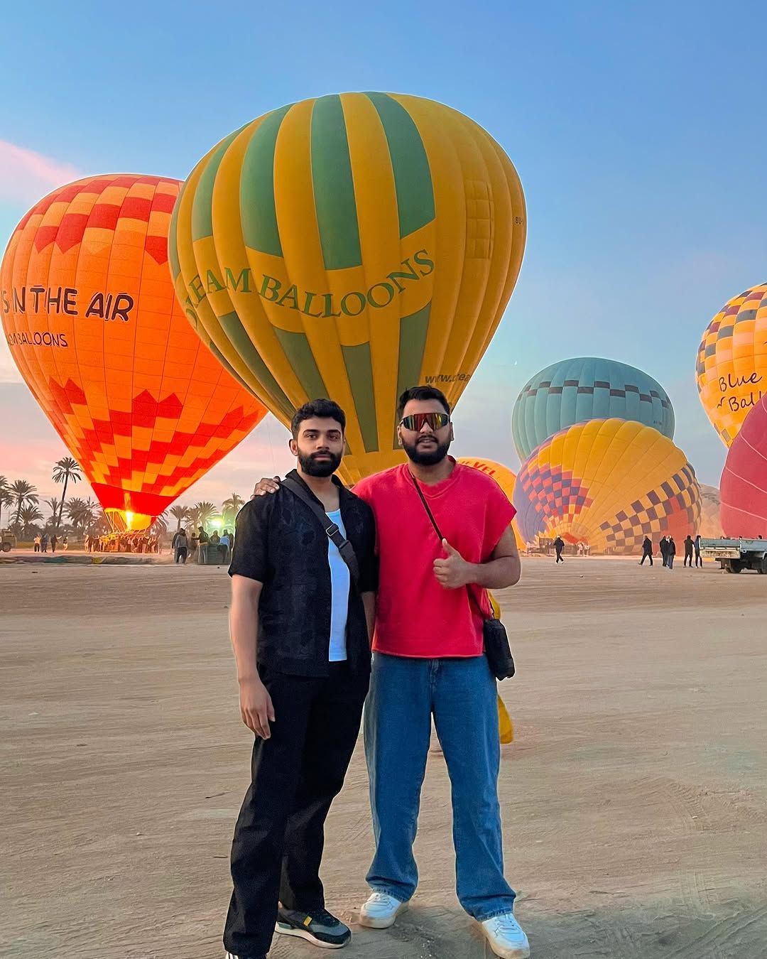 Hot air balloon flying above the green fields of Luxor