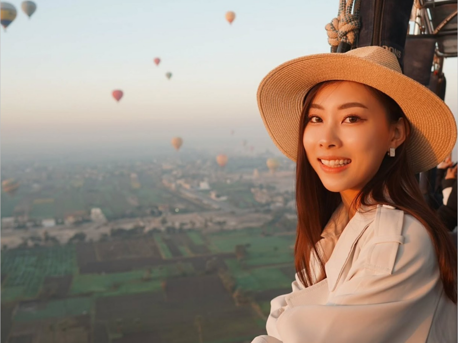 Hot air balloon rising above Luxor at dawn