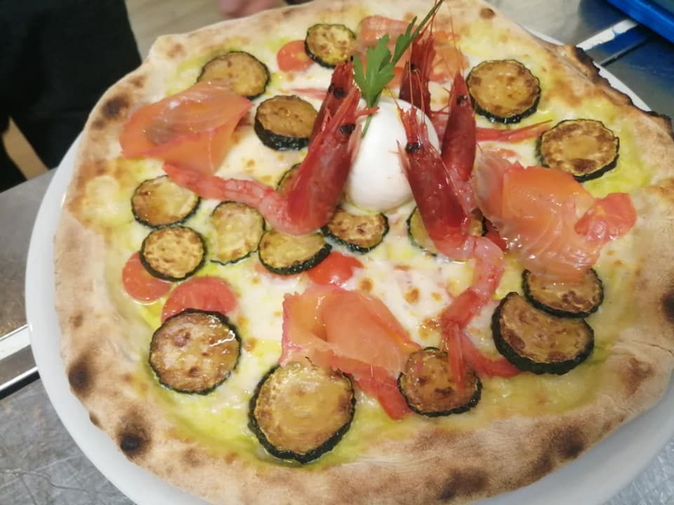 Una pizza con tante verdure sopra