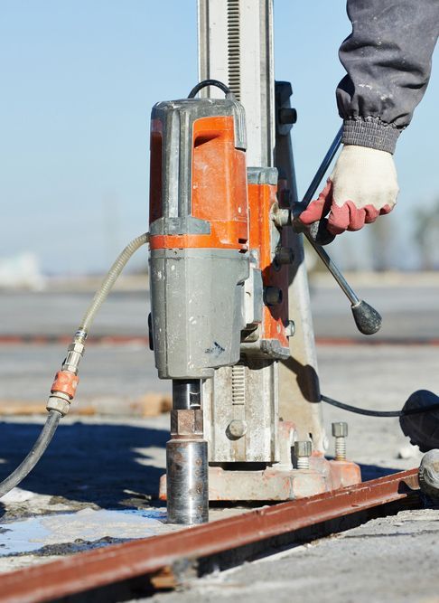 A Person Is Using A Drill On A Construction Site — Wallers Precision Tooling  In Mackay, QLD