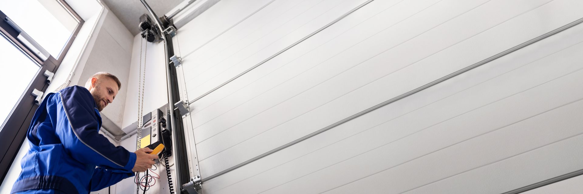 Technician performing residential garage door repair.