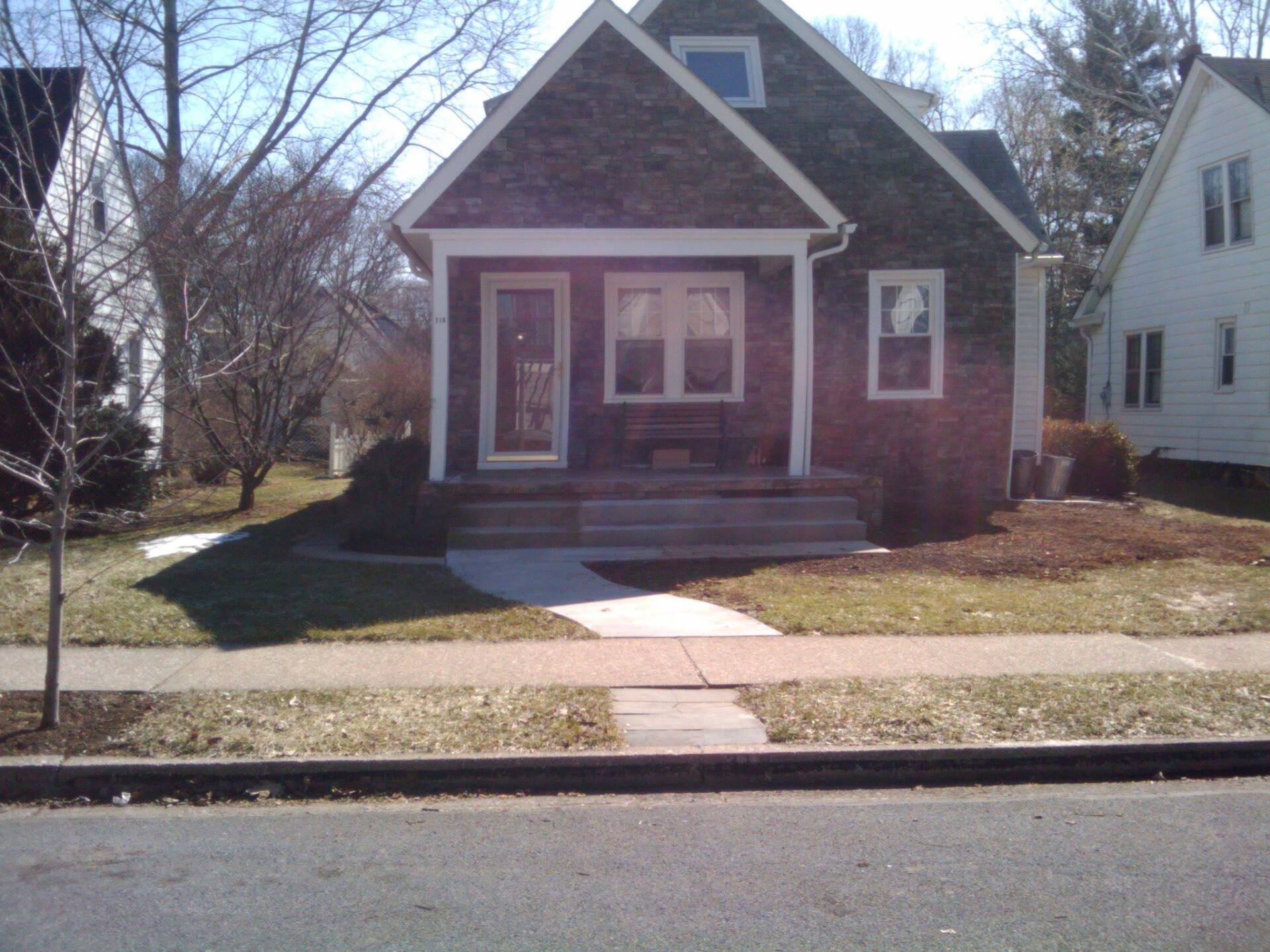 A small brick house with a porch and stairs