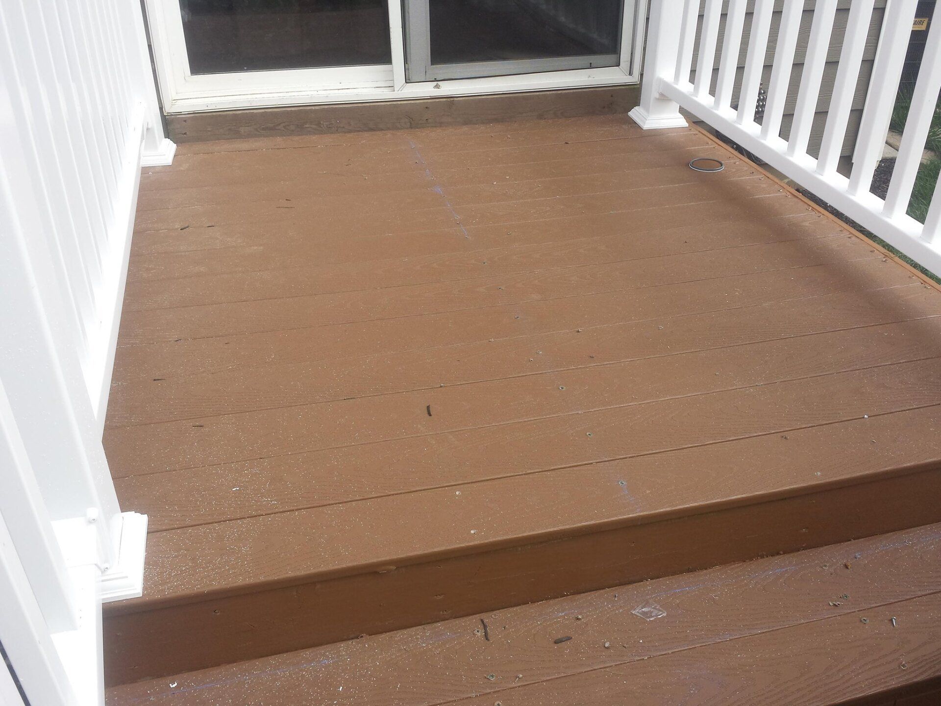 A wooden deck with stairs and a white railing