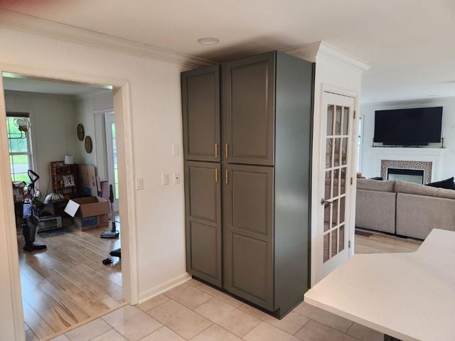 A kitchen with a gray cabinet and a french door.