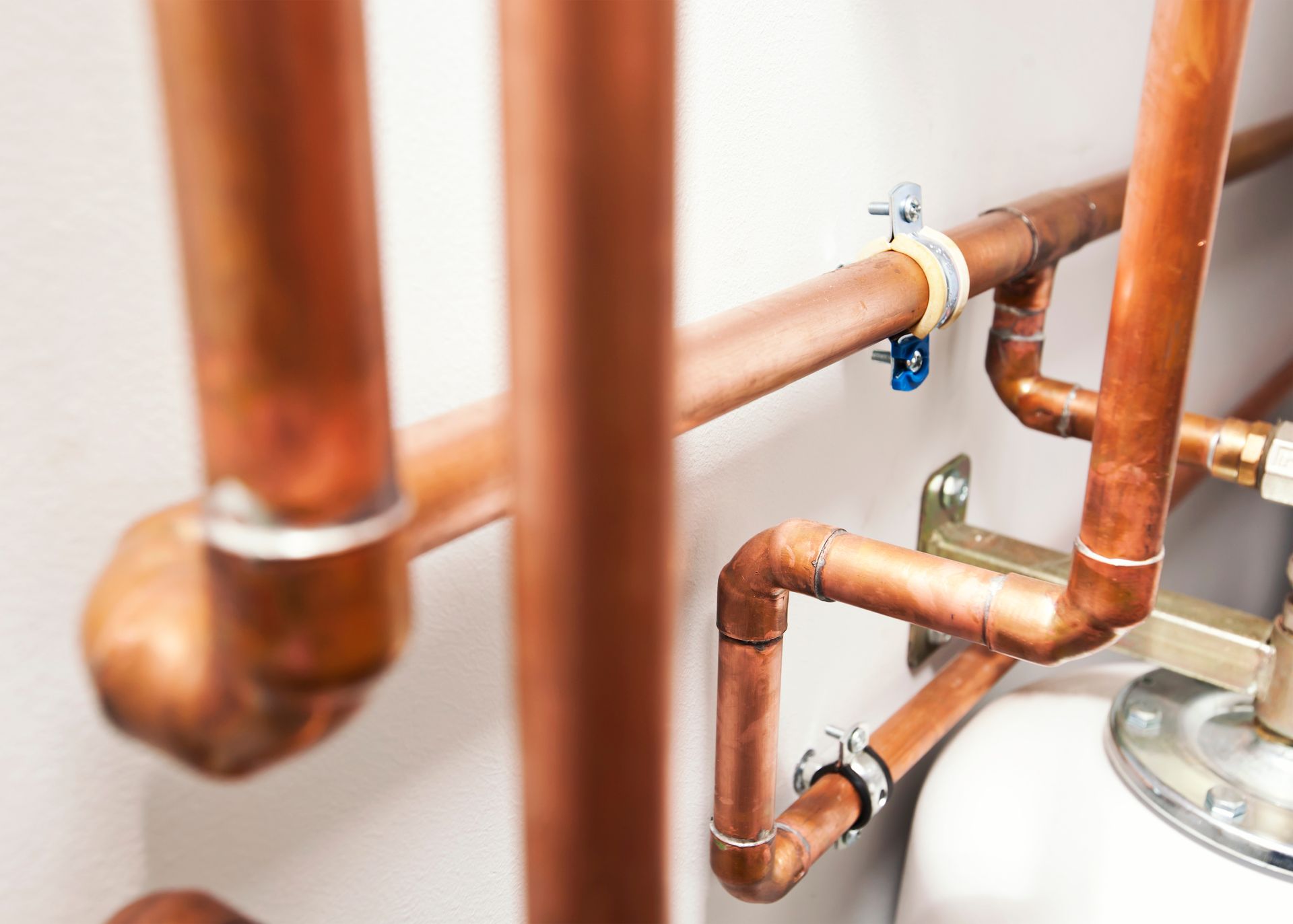 Copper plumbing pipes with red shutoff valves and brass fittings in a wall installation Copper plumbing pipes with red shutoff valves and brass fittings in a wall installation
