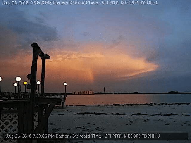 A sunset over a body of water with a dock in the foreground