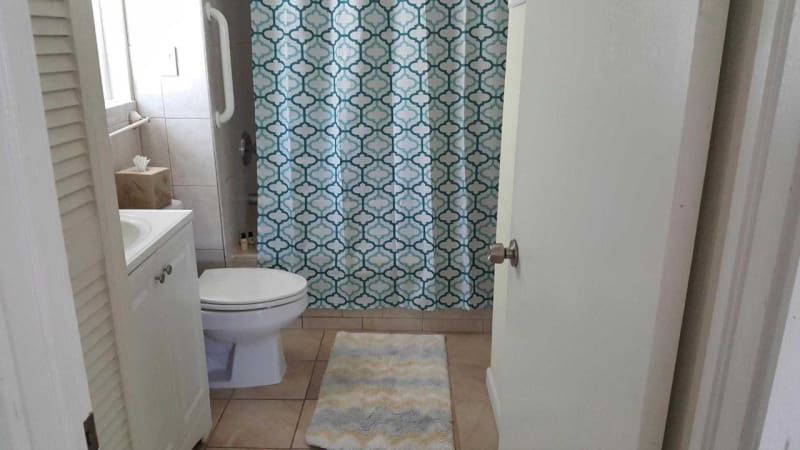 A bathroom with a toilet , sink and shower curtain.