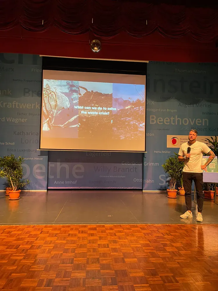 A man is giving a presentation in front of a large screen.