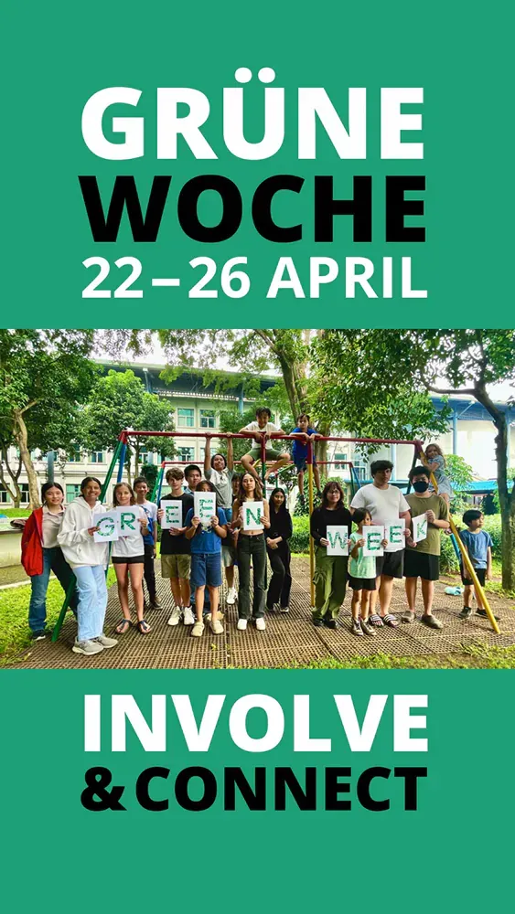 A group of people are standing in a park holding signs.