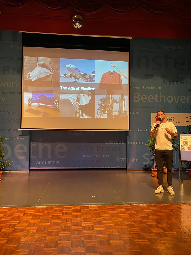 A man is giving a presentation in front of a large screen.