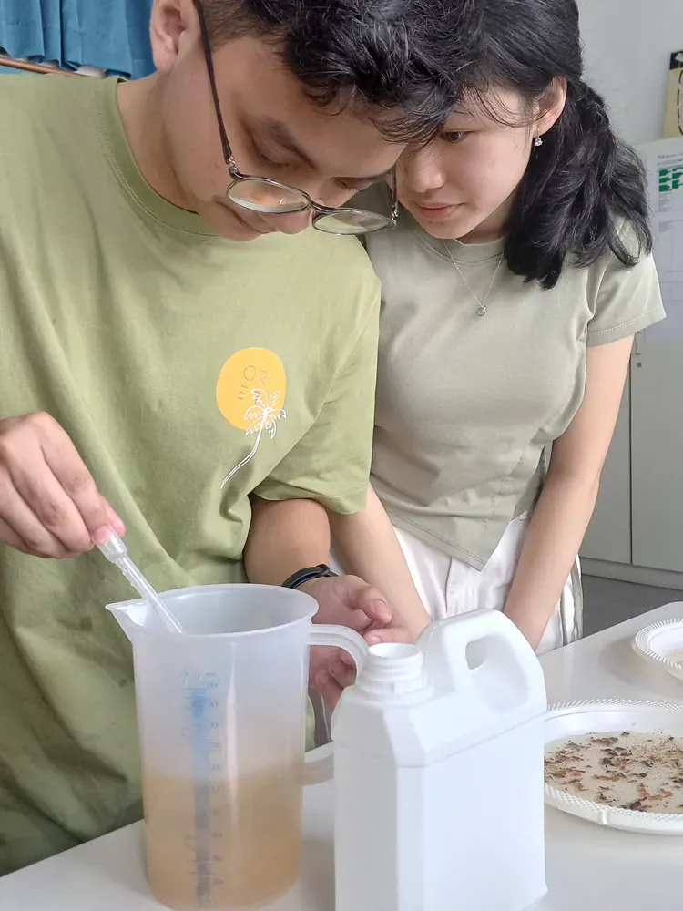 A man and a woman are standing next to each other at a table.