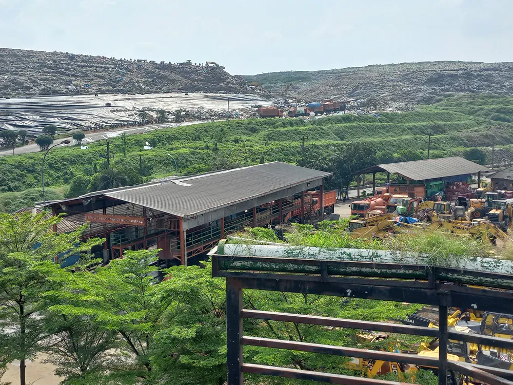 An aerial view of a building in the middle of a lush green field.