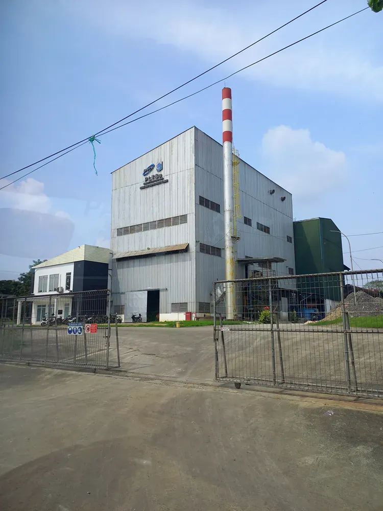 A large building with a red and white chimney in front of it.