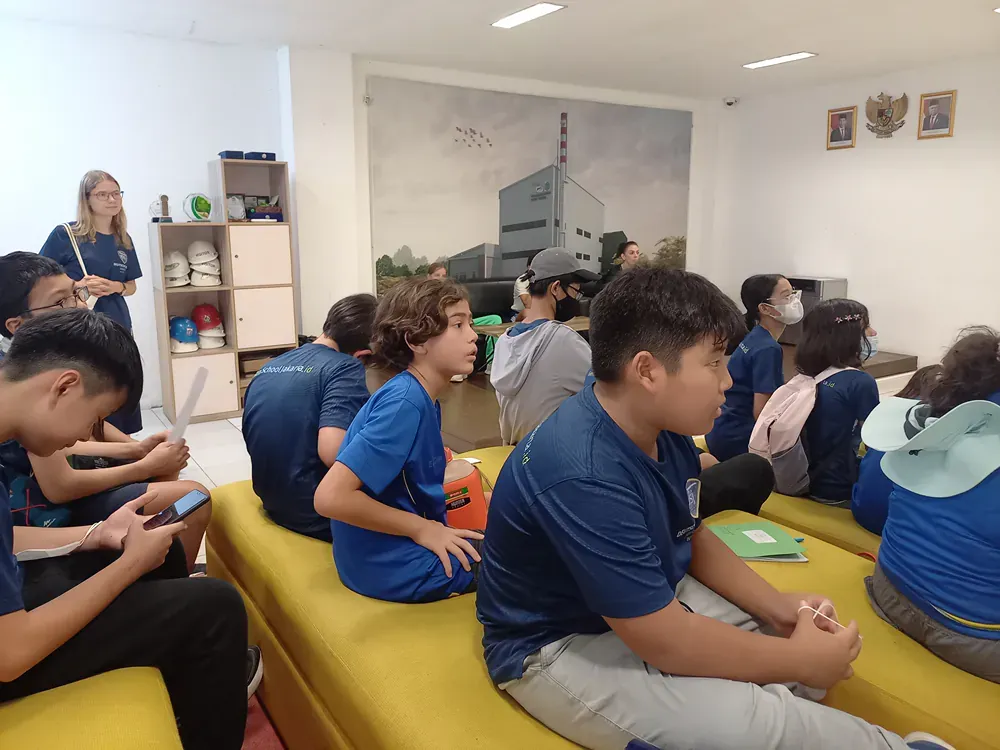 A group of people are sitting on couch looking at their phones.