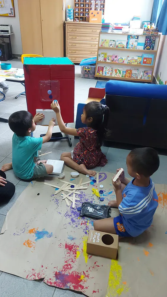 A group of children are sitting on the floor playing with toys.
