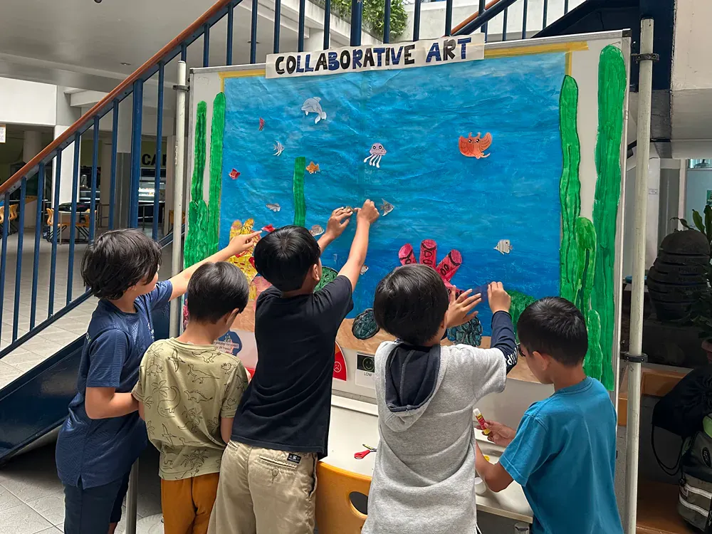 A group of children are working on a collaborative art project.