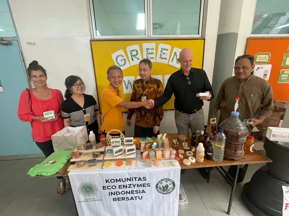 A group of people are standing around a table holding hands.
