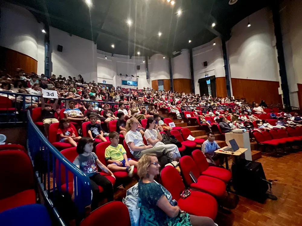 A large group of people are sitting in a large auditorium.