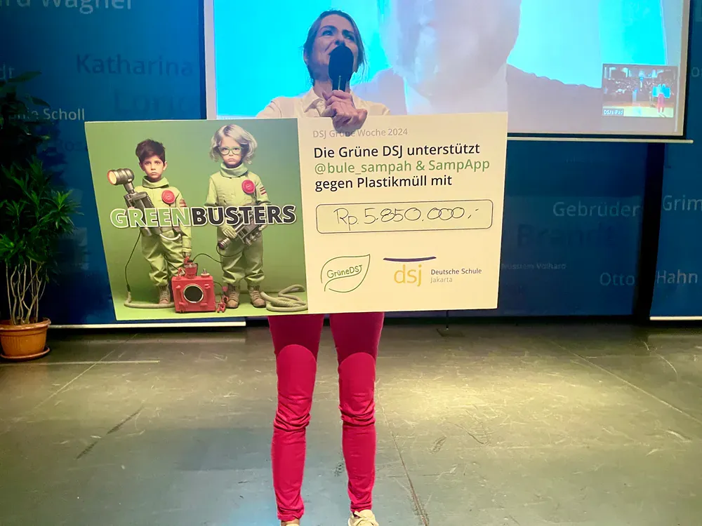 Woman on stage holding a large check with a