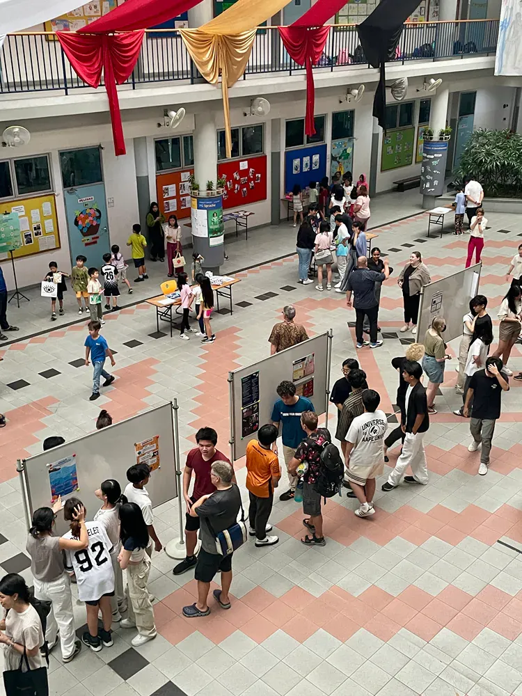 A group of people are standing around a display in a building.