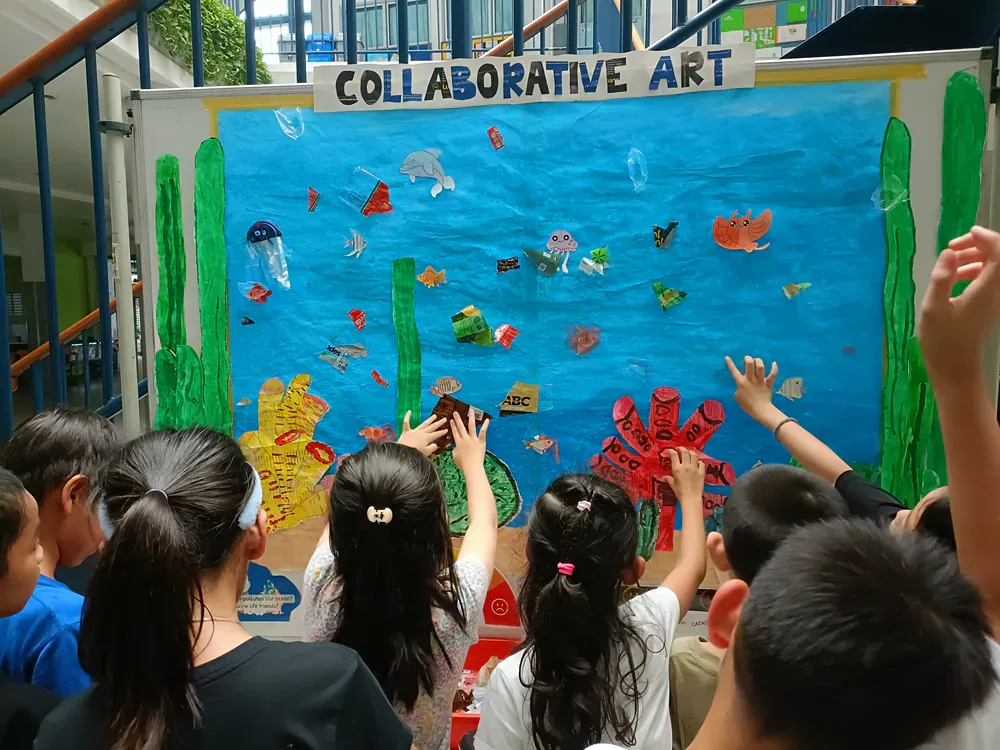A group of children are looking at a collaborative art display