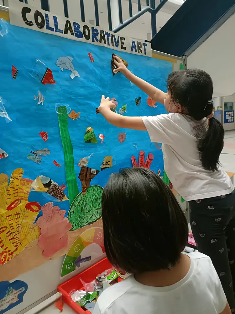 Two young girls are working on a collaborative art project