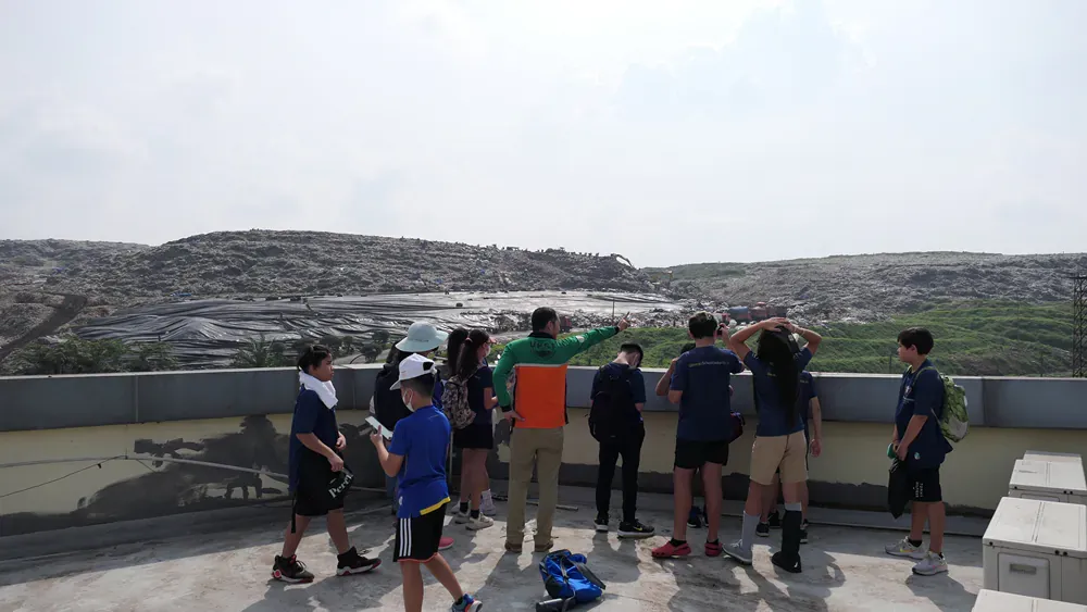 A group of children are standing on top of a building looking out over a city.