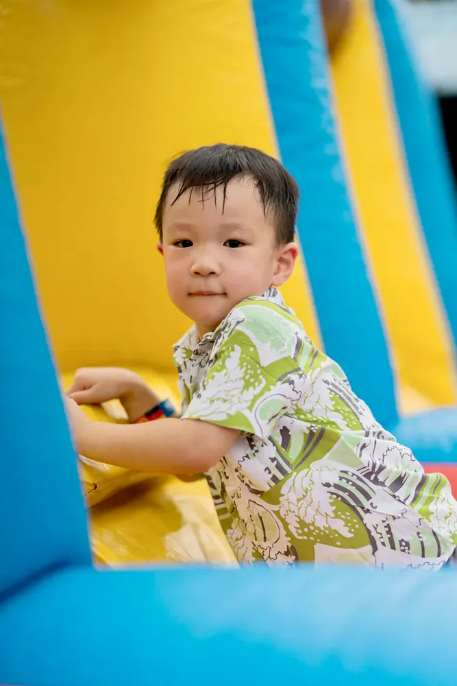 A young boy is playing in an inflatable bouncy house.