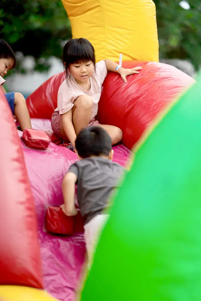 A group of children are playing on a bouncy house.