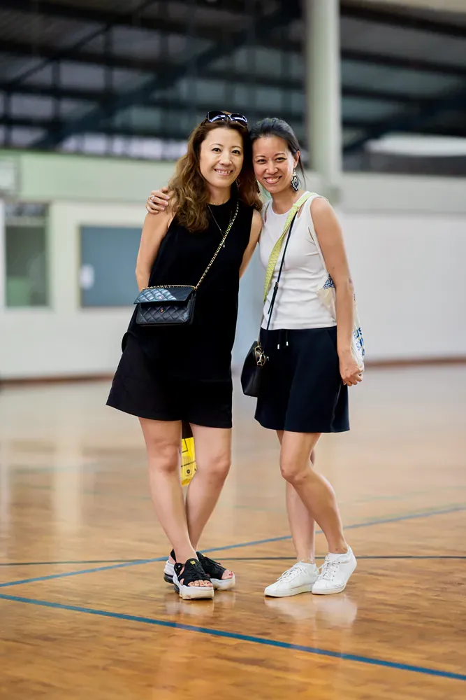 Two women are standing next to each other on a basketball court.