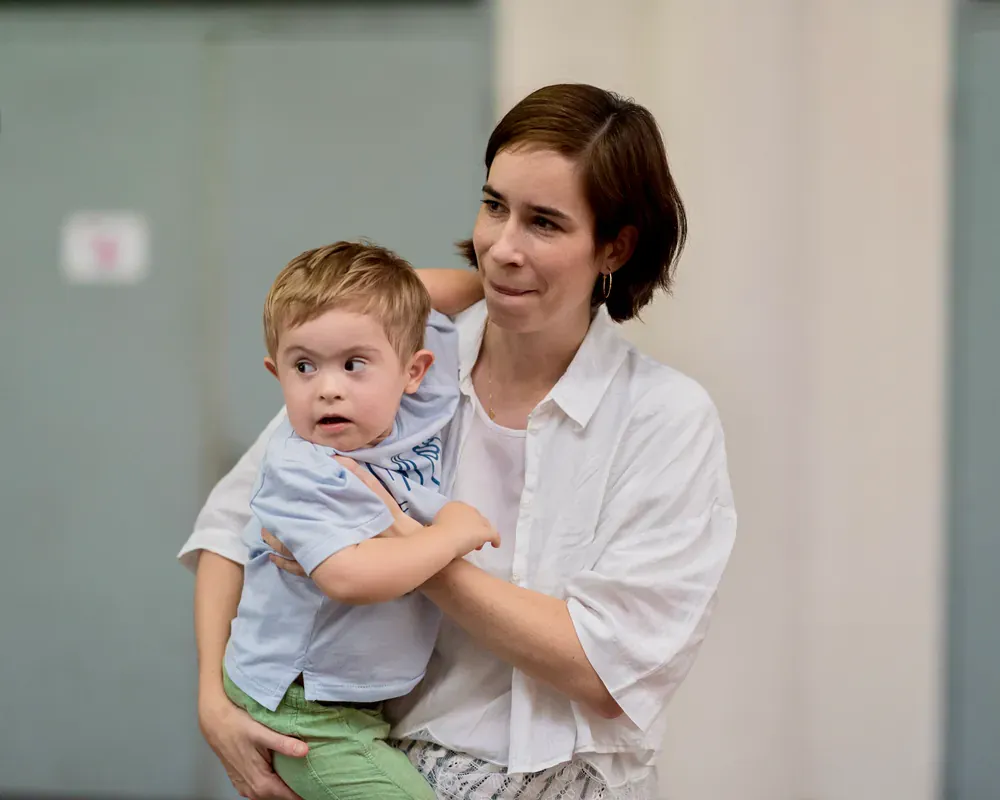 A woman is holding a little boy in her arms.