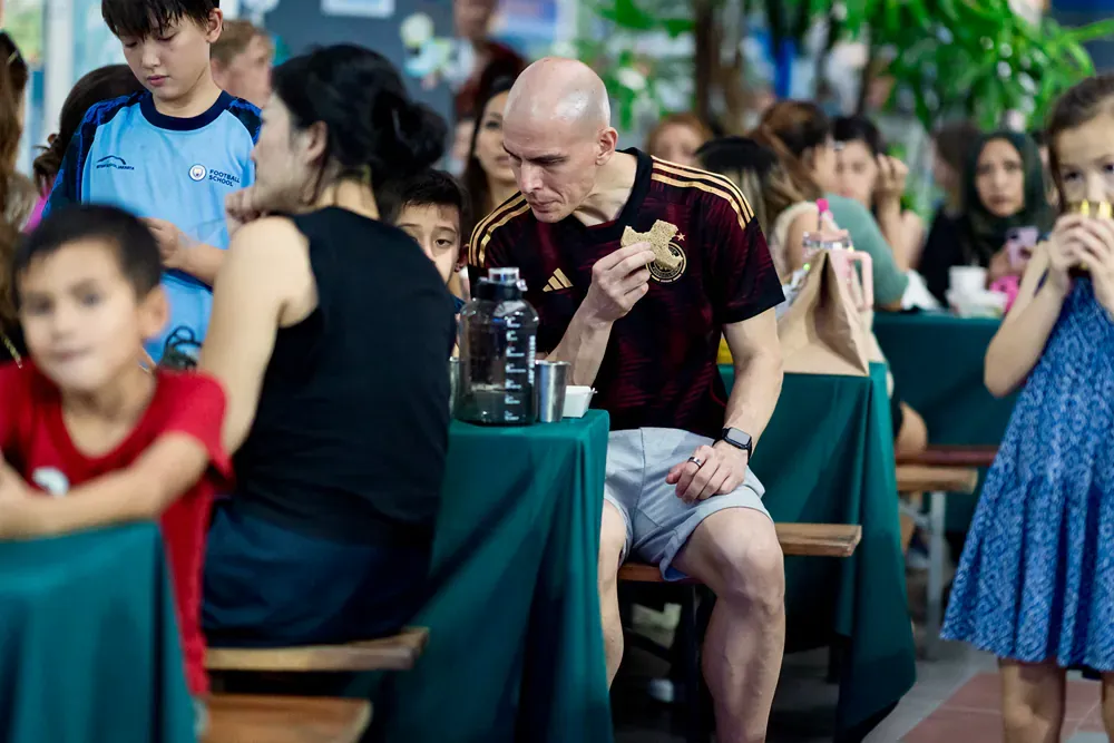 A man is sitting at a table eating a sandwich.