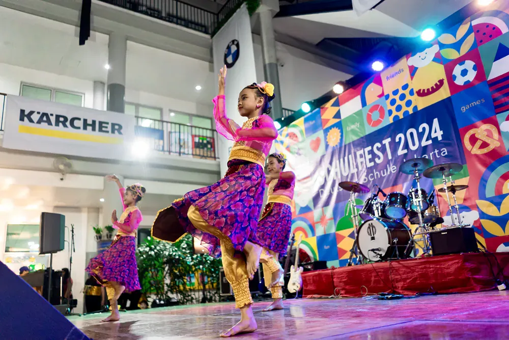 A group of young girls are dancing on a stage.