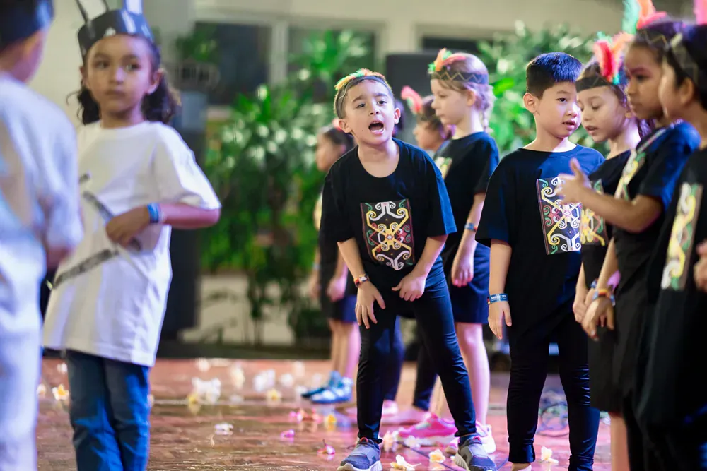 A group of children are standing next to each other on a stage.