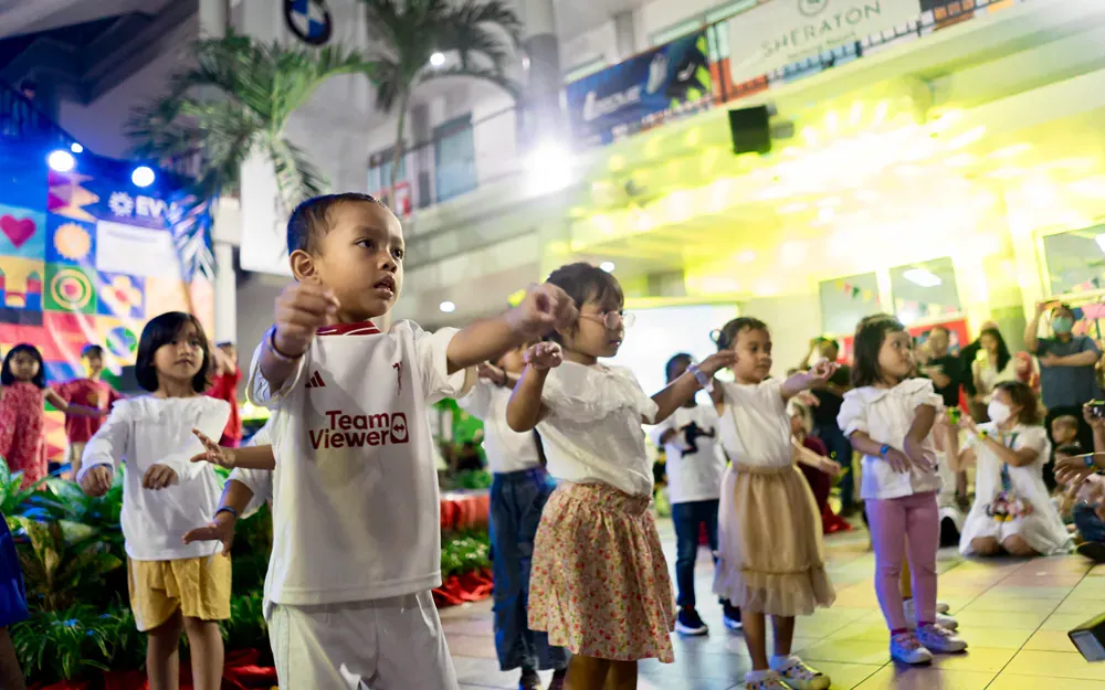A group of children are dancing in front of a crowd.