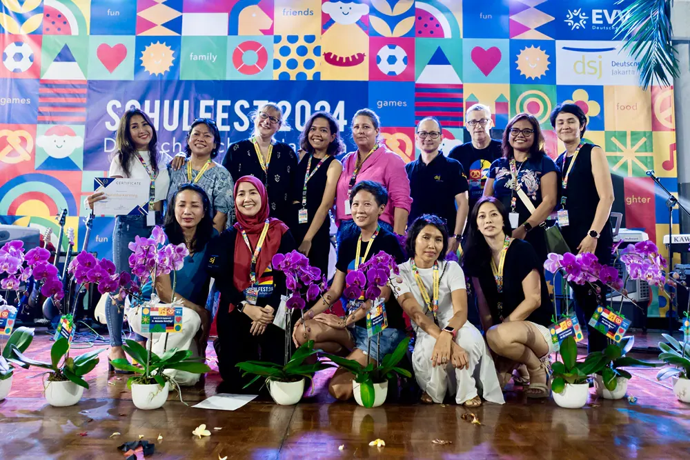 A group of people are posing for a picture in front of a colorful wall.