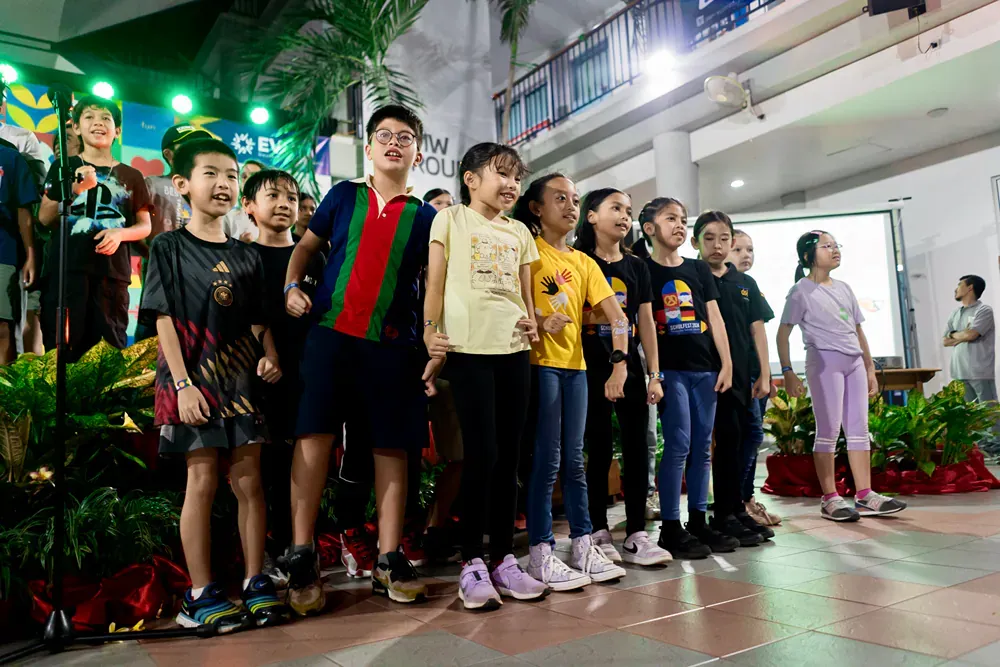 A group of children are standing next to each other on a stage.