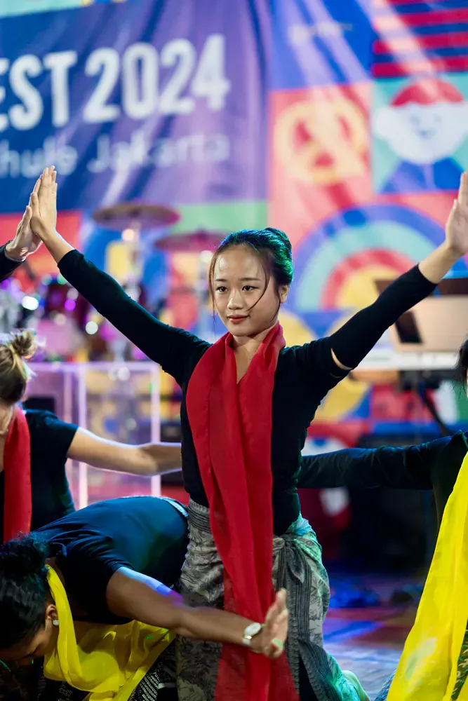 A group of people are dancing on a stage at a festival.