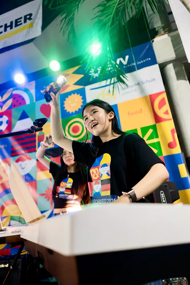 A woman is singing into a microphone on a stage.