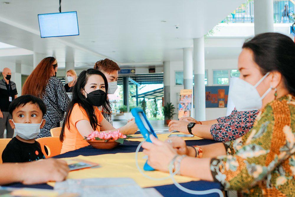 A group of people wearing face masks are sitting at a table.