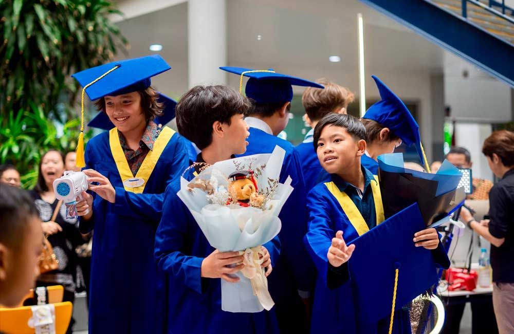A group of graduates are standing next to each other holding a bouquet of flowers.