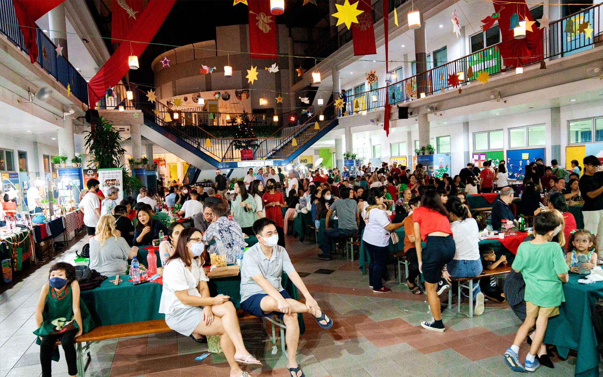 A large group of people are sitting at tables in a large room.