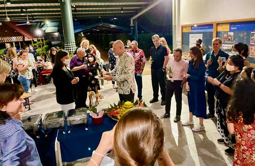 A group of people are standing around a table at a party.