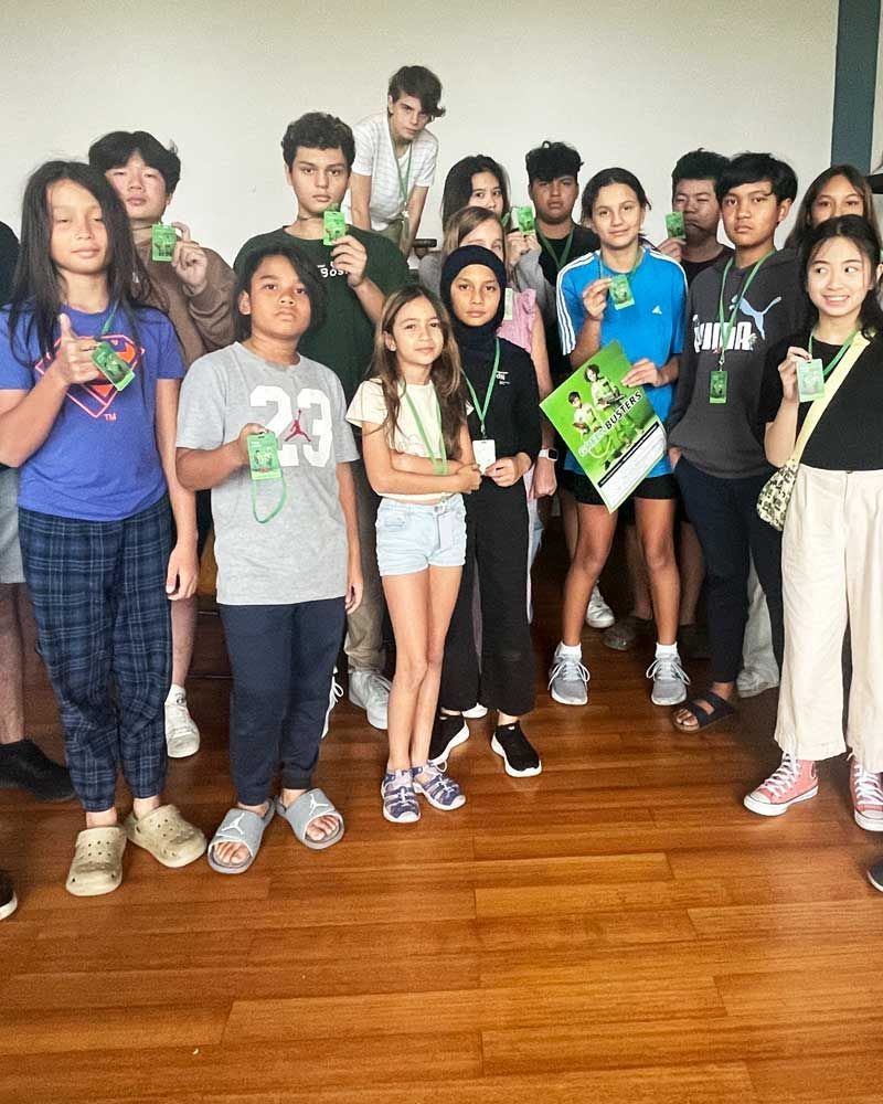 A group of young people are posing for a picture on a wooden floor.