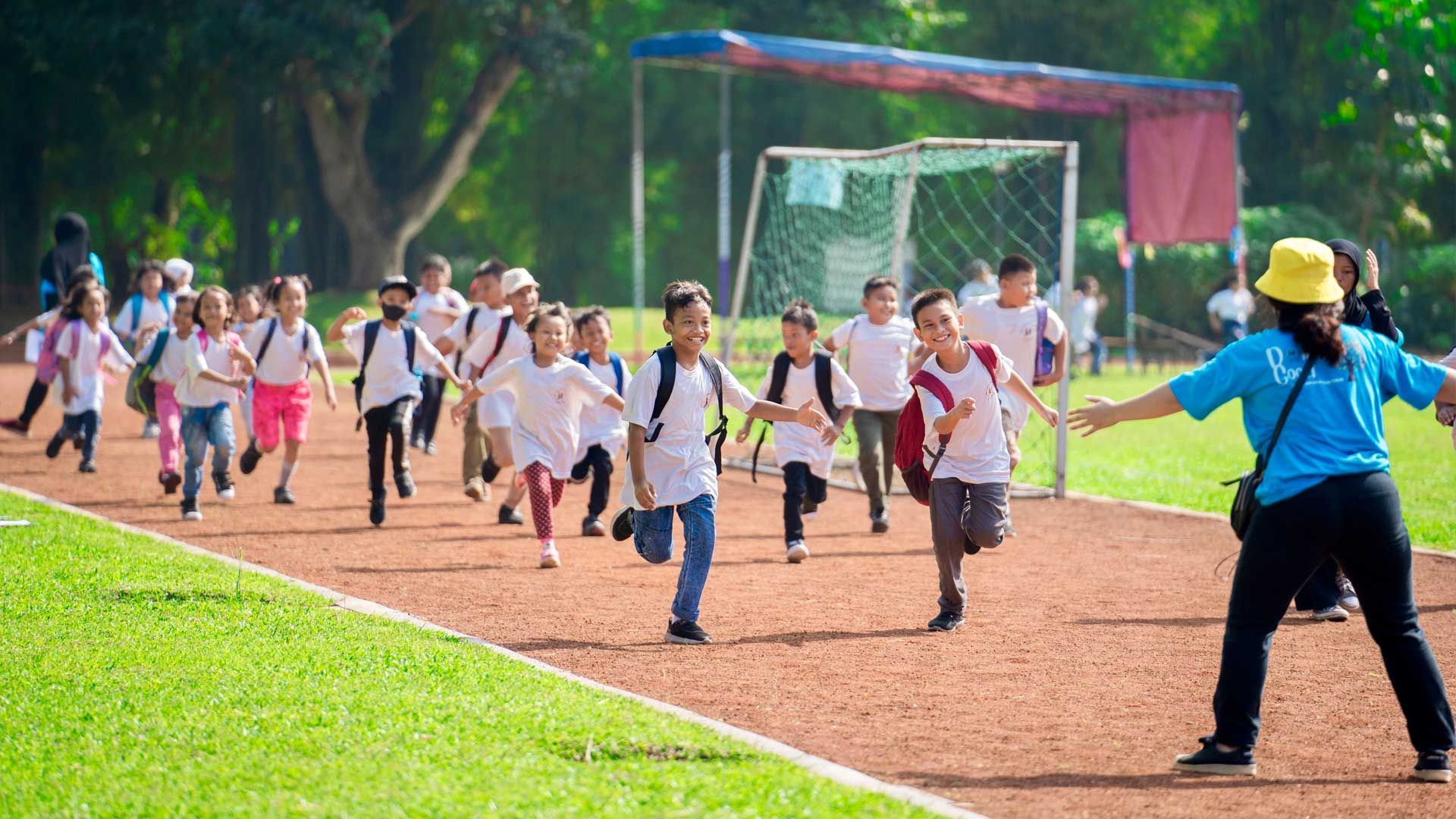 A group of children are running on a track.