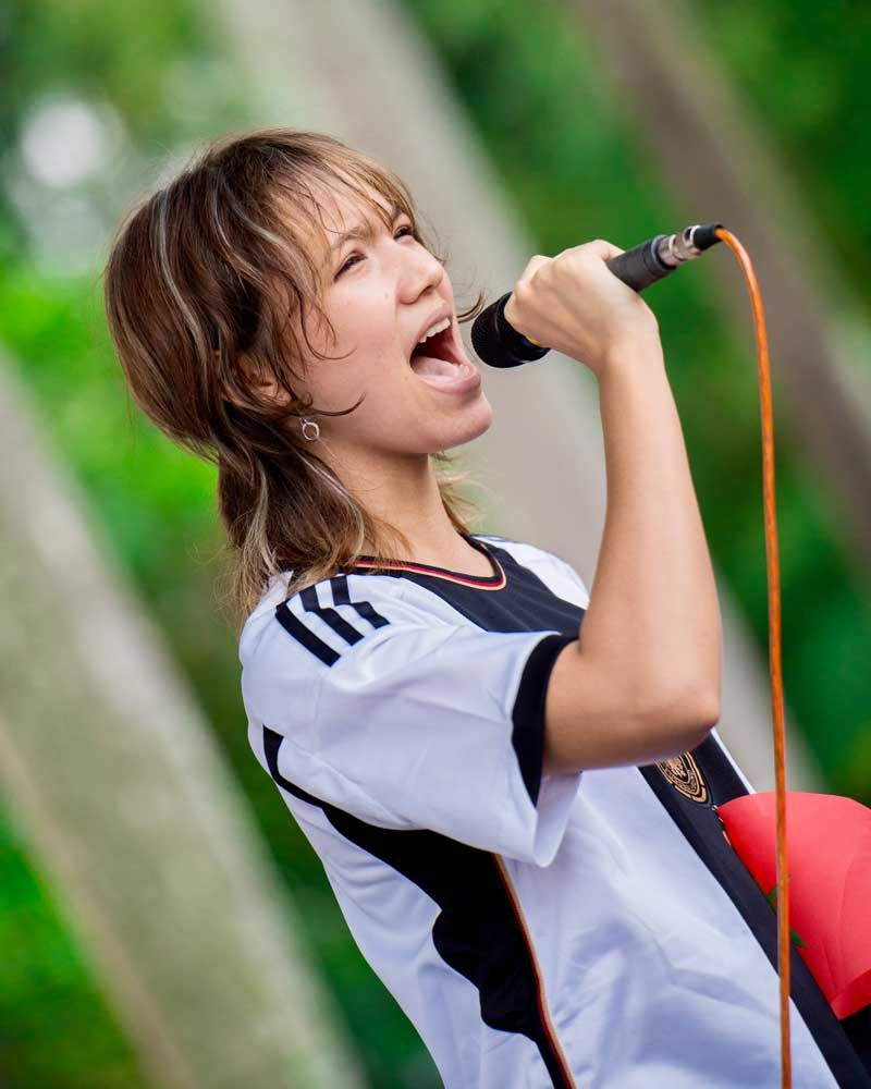 A woman is singing into a microphone with her mouth open.