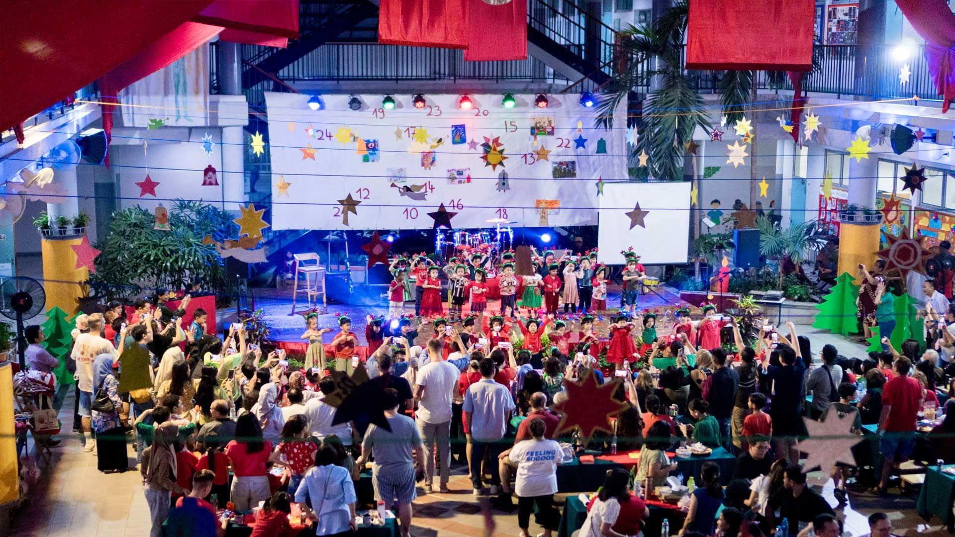 a large crows of people are gathered at a German school christmas party